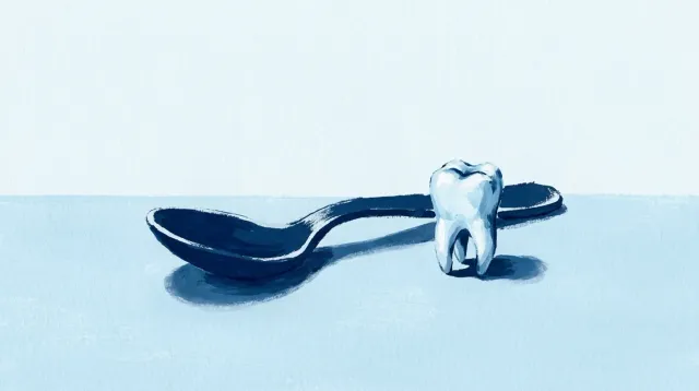 Una cuchara pequeña y un diente de leche sobre la mesa