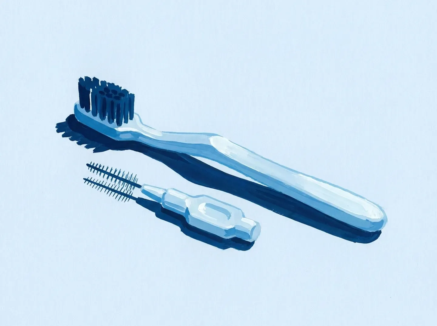 Un cepillo y un cepillo interdental sobre la mesa