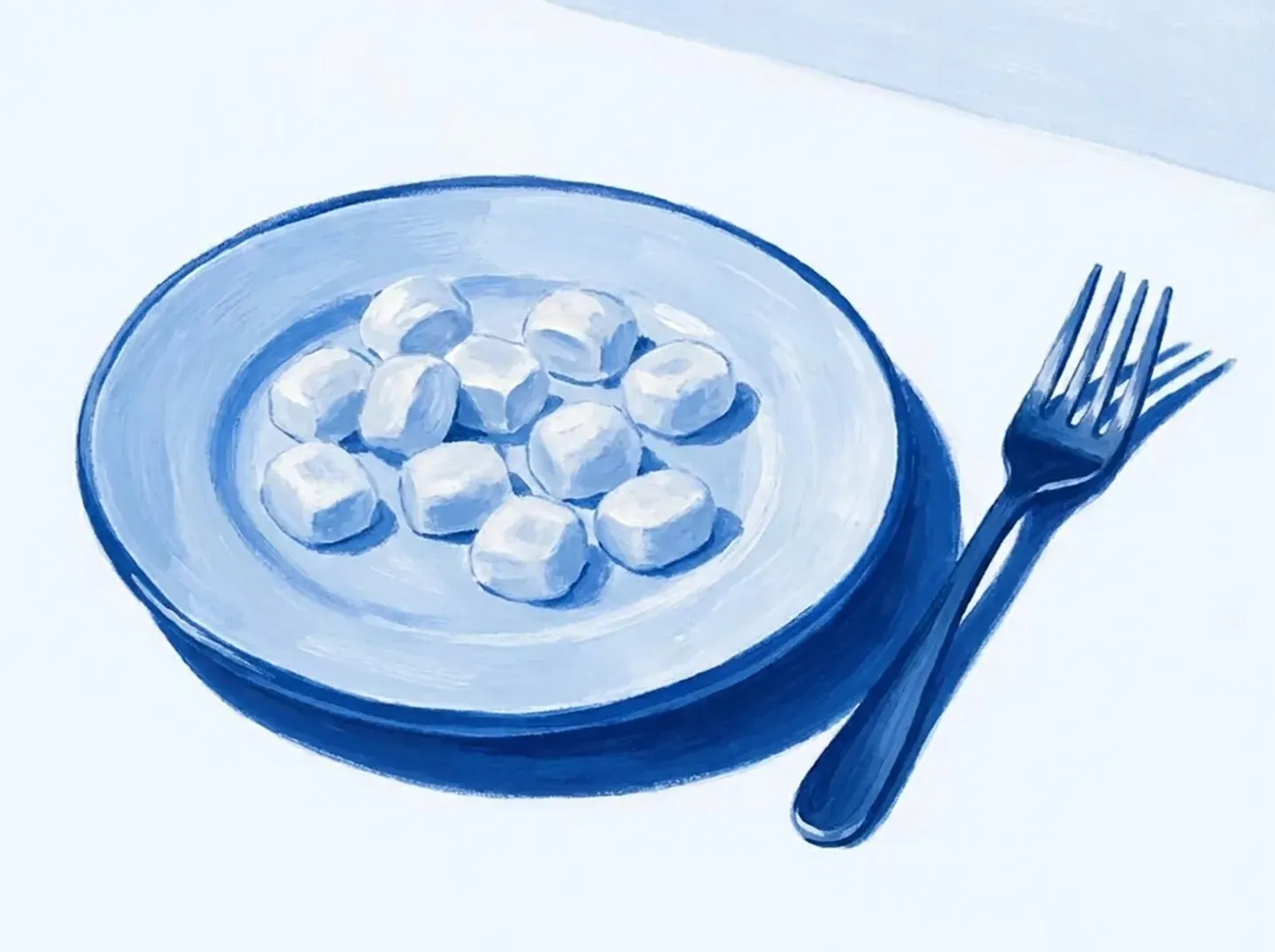 Un plato con la comida cortada en trozos pequeños y un tenedor al lado