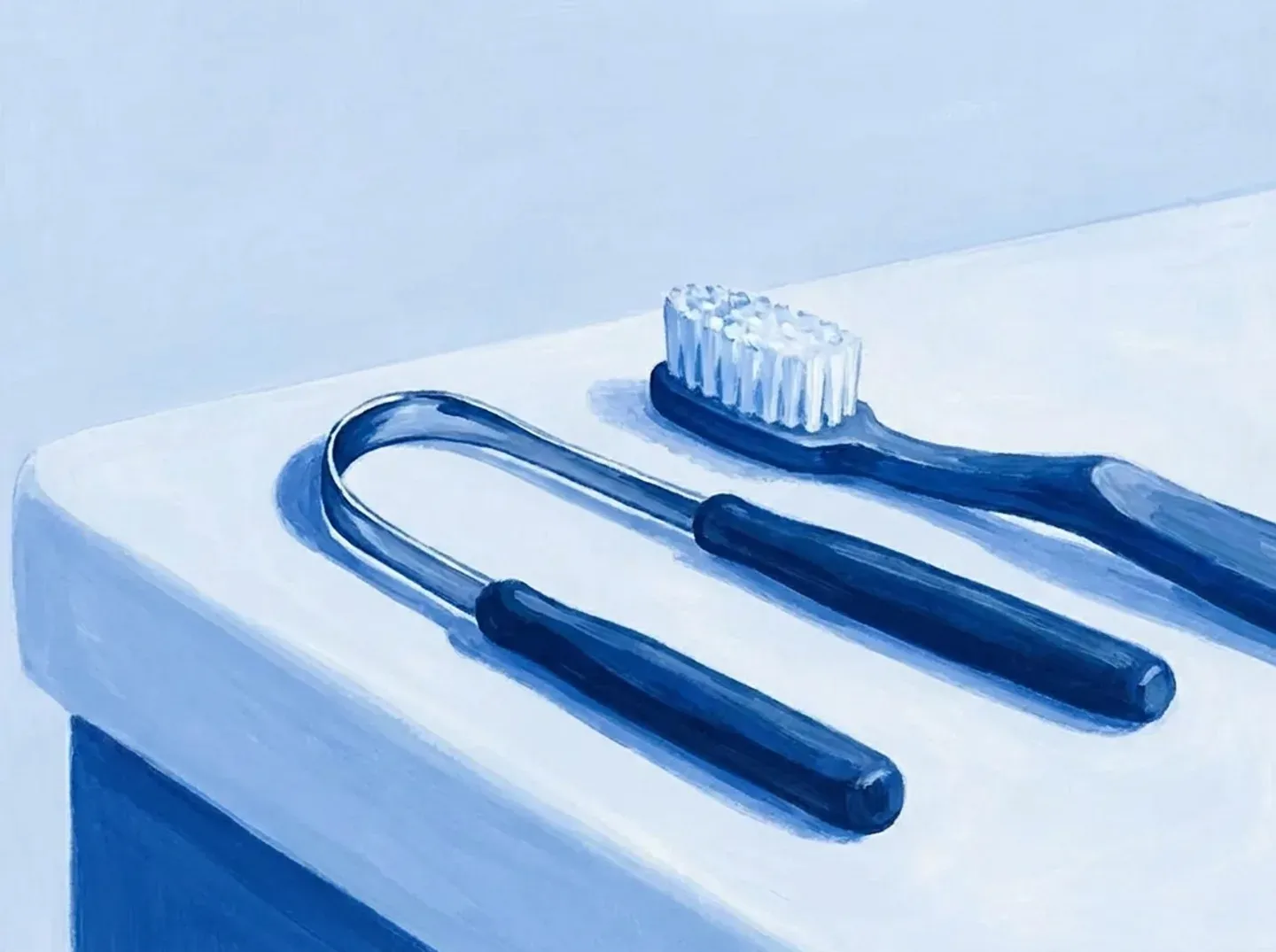 El raspador y un cepillo de dientes, uno al lado del otro sobre la repisa