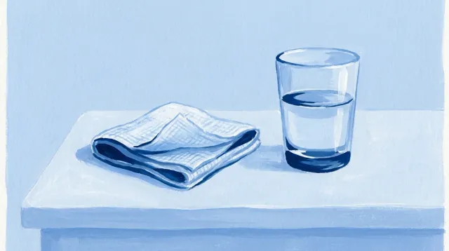 Una gasa doblada y un vaso de agua sobre la mesilla